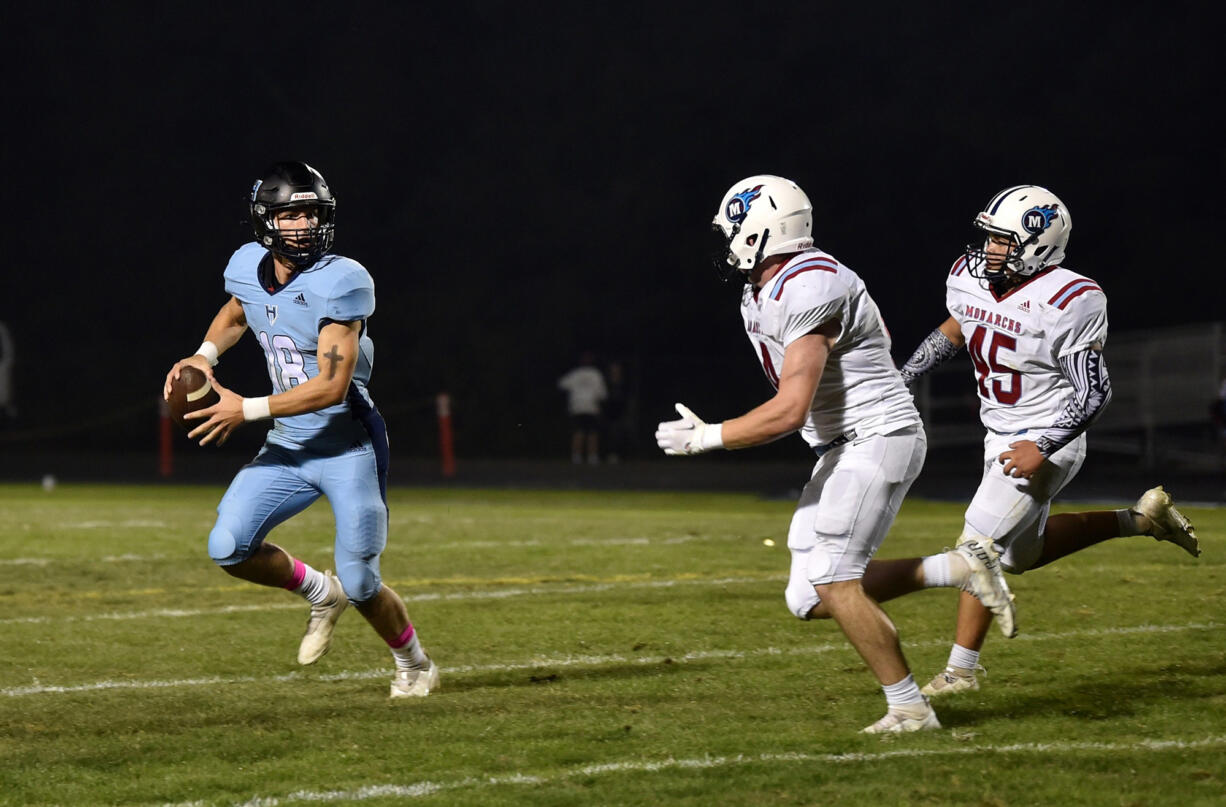 Hockinson quarterback Jarod Oldham scrambles to avoid the Mark Morris defenders during Friday’s game at Hockinson.