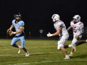 Hockinson quarterback Jarod Oldham scrambles to avoid the Mark Morris defenders during Friday’s game at Hockinson.