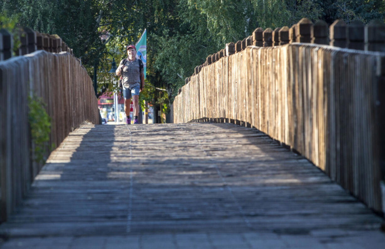 Rue McKenrick of Bend, Ore., crosses the pedestrian bridge into Drake Park to complete his final scouting trip of the 14,000-mile American Perimeter Trail.