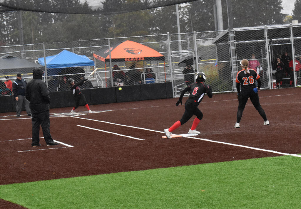 Union's Makenna Johnson hits the ball as Sophia Richard (6) takes off from first base and Battle Ground Makenzy Newton (26) looks on during the 4A district slowpitch softball playoff at Heritage High School on Friday, Oct. 21, 2022.