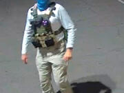 An armed individual dressed in tactical gear at a ballot drop box in Mesa, Arizona, on Oct. 21, 20221.