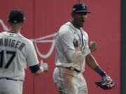 Seattle Mariners center fielder Julio Rodriguez, right, celebrates after making a catch for an out against the Houston Astros, during the 16 inning in Game 3 of an American League Division Series baseball game Saturday, Oct. 15, 2022, in Seattle.