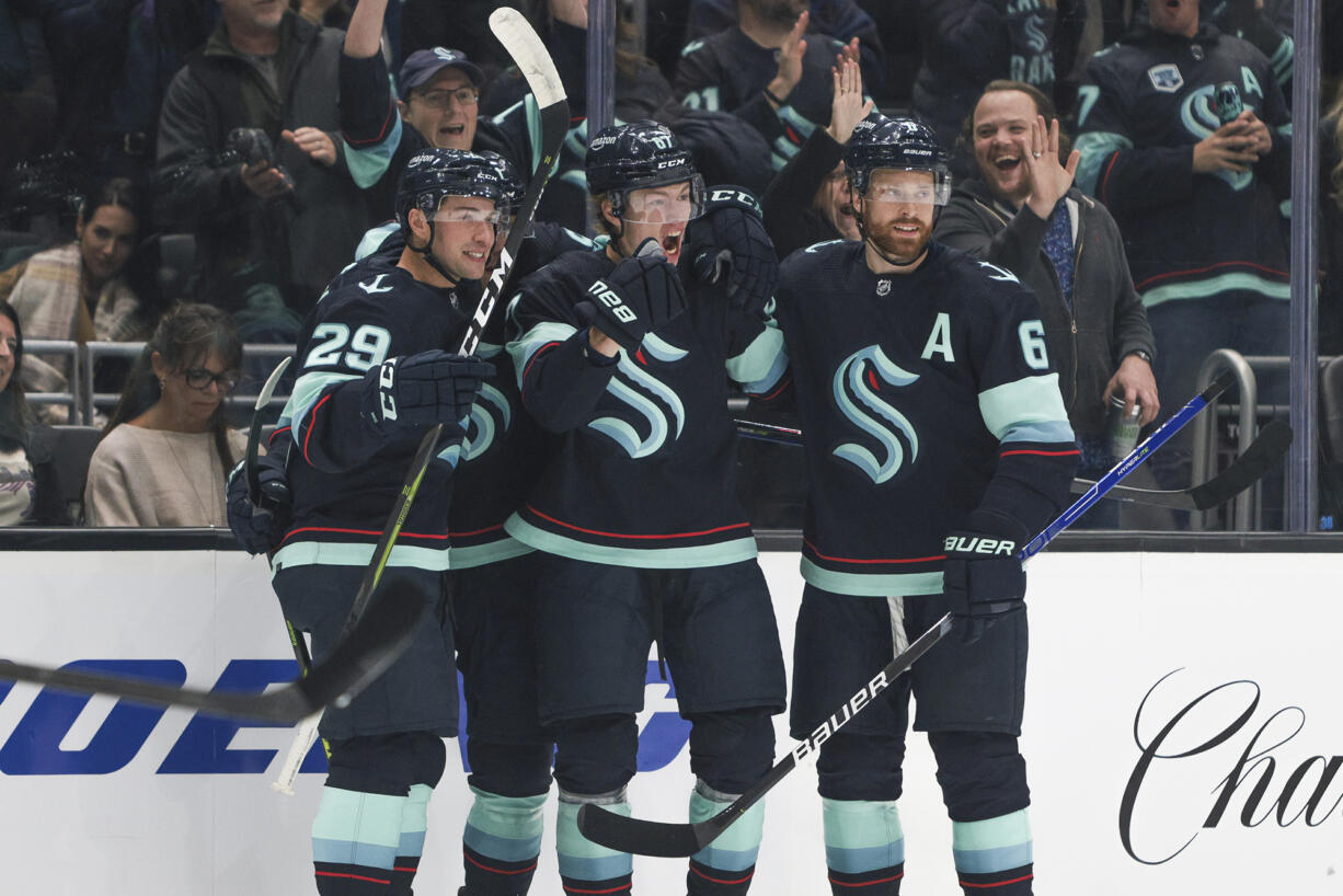 Seattle Kraken center Morgan Geekie, center, celebrates with teammates Vince Dunn (29) and Adam Larsson (6) after scoring a goal during the first period of an NHL hockey game against the Buffalo Sabres, Tuesday, Oct. 25, 2022, in Seattle.