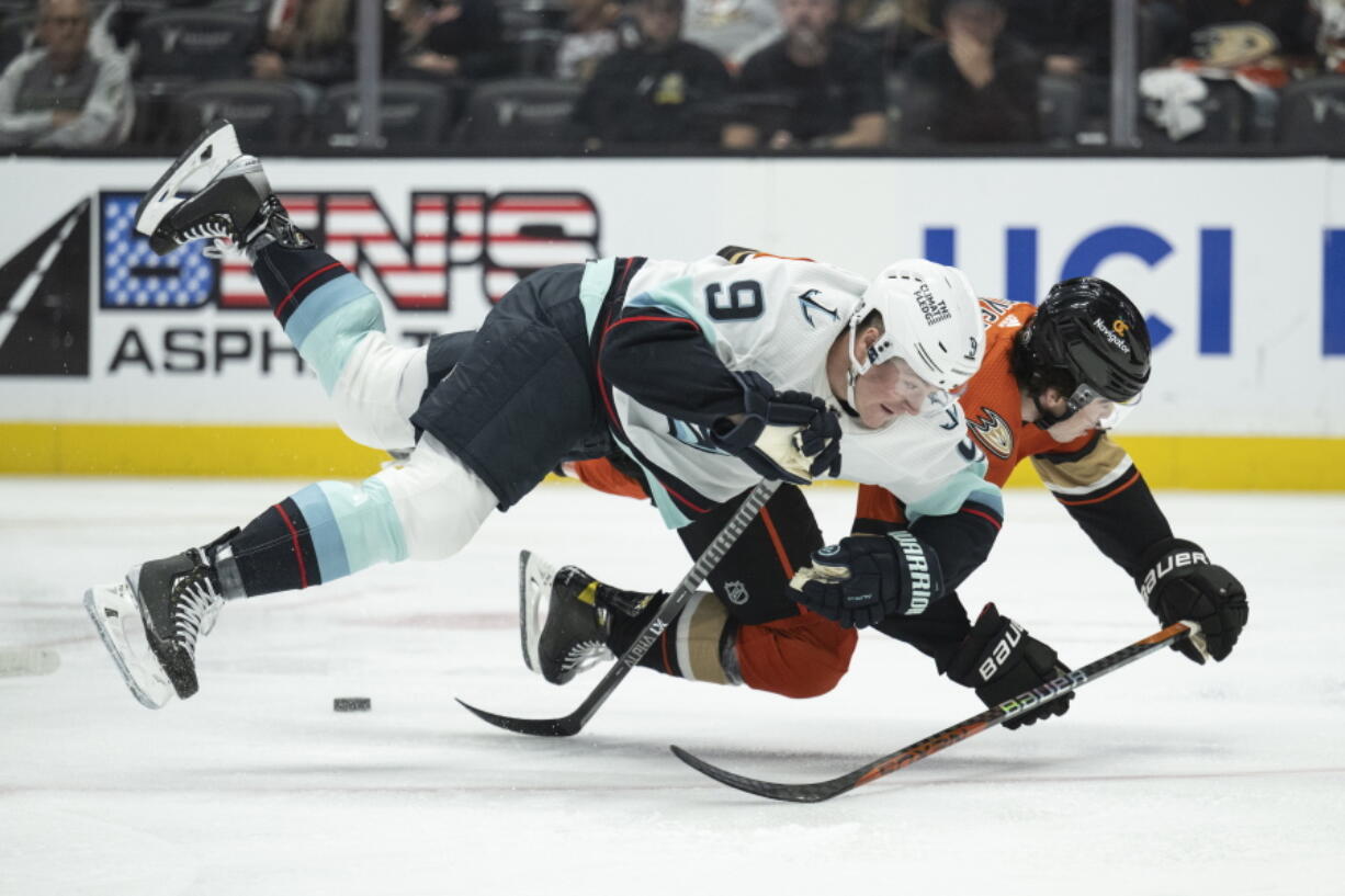 Seattle Kraken center Ryan Donato (9) and Anaheim Ducks defenseman Jamie Drysdale (6) trip while vying for the puck during the first period of an NHL hockey game in Anaheim, Calif., Wednesday, Oct. 12, 2022.