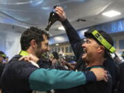 Seattle Mariners manager Scott Servais, right, celebrates in the clubhouse after the team's baseball game against the Oakland Athletics, Friday, Sept. 30, 2022, in Seattle. The Mariners won 2-1 to clinch a spot in the playoffs.