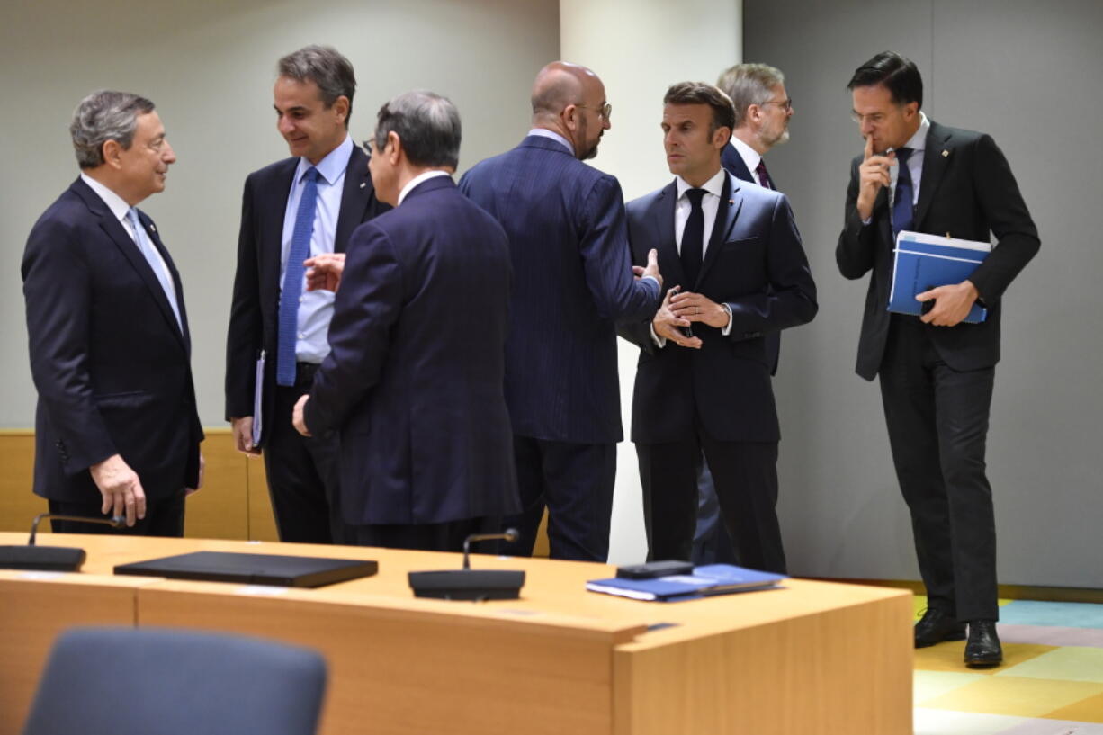 European Council President Charles Michel, center left, speaks with French President Emmanuel Macron, center right, during a round table meeting at an EU summit in Brussels, Friday, Oct. 21, 2022. European Union leaders are gathering Friday to take stock of their support for Ukraine after President Volodymyr Zelenskyy warned that Russia is trying to spark a refugee exodus by destroying his war-ravaged country's energy infrastructure.