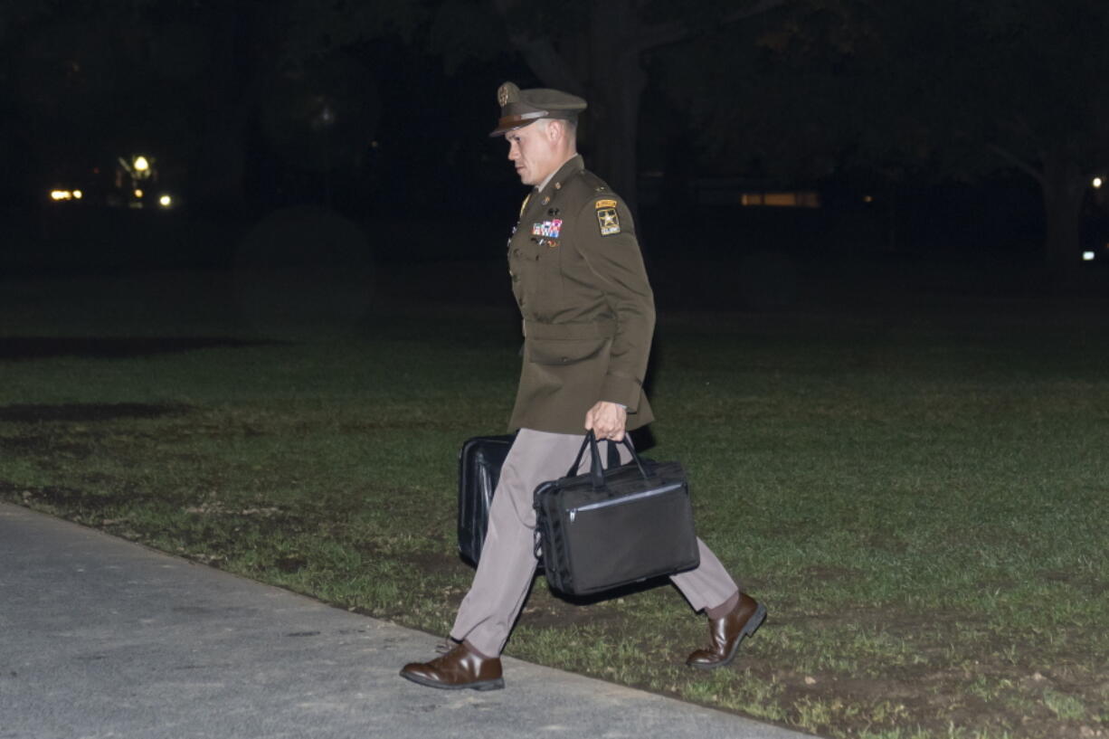 A U.S. Army officer military aide carries the nuclear launch codes known as the "football," as he follows President Joe Biden into the White House after arriving on Marine One, Thursday, Oct. 6, 2022, in Washington. Biden is returning from New York and New Jersey.