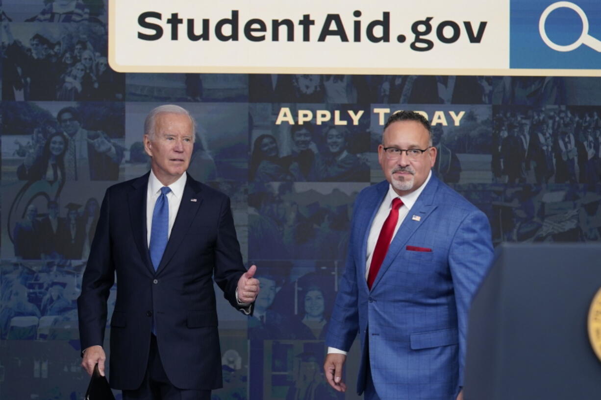 President Joe Biden answers questions with Education Secretary Miguel Cardona as they leave an event about the student debt relief portal beta test in the South Court Auditorium on the White House complex in Washington, Monday, Oct. 17, 2022.