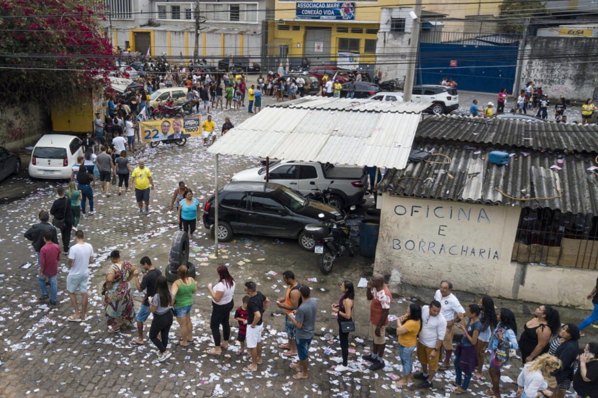 Voters line up at a polling post in the Mare neighborhood in Rio de Janeiro, Brazil, Sunday, Oct. 2, 2022.