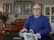 Jeffrey Reed, who experienced persistent sinus infections and two bouts of pneumonia while using a Philips CPAP machine, poses with the device at his home Thursday, Oct. 20, 2022, in Marysville, Ohio. The device is part of a massive global recall of breathing machines triggered by sound-dampening foam that can break down, releasing potentially harmful particles and chemicals.