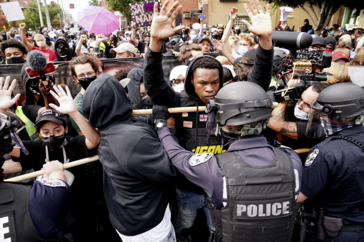 Police and protesters converge during a demonstration Sept. 23, 2020, in Louisville, Ky. Recent revelations about the search warrant that led to Breonna Taylor's death have reopened old wounds in Louisville's Black community and disrupted the city's efforts to restore trust in the police department.