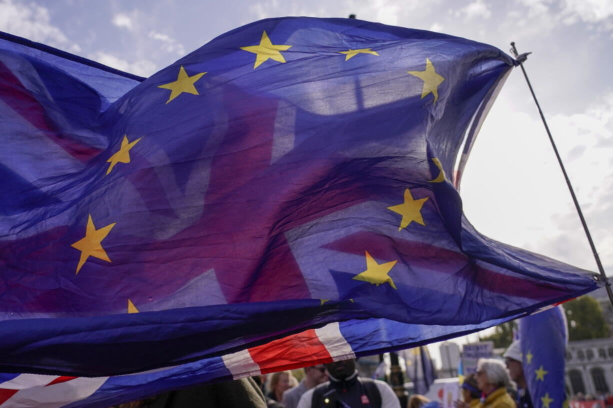 A Union flag waves behind a European Union flag, outside the Houses of Parliament, in London, Wednesday, Oct. 19, 2022. Since the shock 2016 referendum vote to leave the European Union, Britain has seen years of bitter wrangling with the EU, two general elections and three prime ministers. The pound fell 0.75% against the U.S. dollar to $1.1273 in late morning trading in London, after jumping as much as 1.2% on Monday.