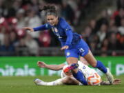 United States' Sophia Smith challenges for the ball with England's Millie Bright, bottom, during the women's friendly soccer match between England and the US at Wembley stadium in London, Friday, Oct. 7, 2022.