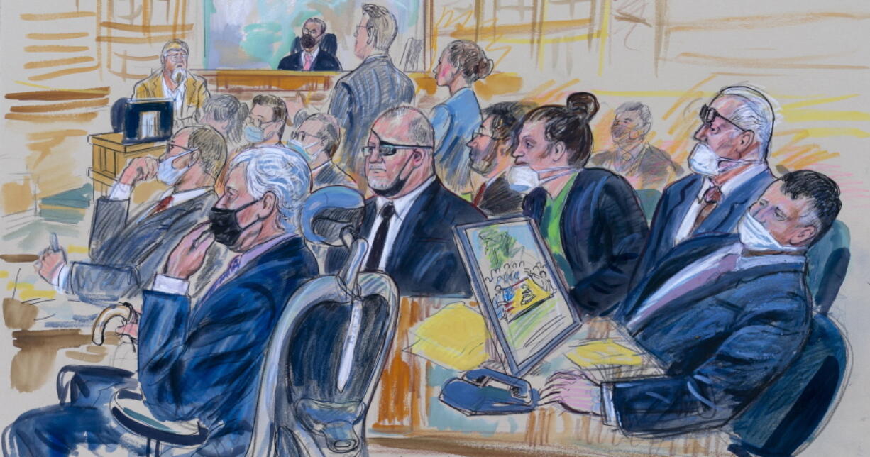 This artist sketch depicts the trial of Oath Keepers leader Stewart Rhodes and four others charged with seditious conspiracy in the Jan. 6, 2021, Capitol attack, in Washington, Thursday, Oct. 6, 2022. Shown above are, witness John Zimmerman, who was part of the Oath Keepers' North Carolina Chapter, seated in the witness stand, defendant Thomas Caldwell, of Berryville, Va., seated front row left, Oath Keepers leader Stewart Rhodes, seated second left with an eye patch, defendant Jessica Watkins, of Woodstock, Ohio, seated third from right, Kelly Meggs, of Dunnellon, Fla., seated second from right, and defendant Kenneth Harrelson, of Titusville, Fla., seated at right. Assistant U.S. Attorney Kathryn Rakoczy is shown in blue standing at right before U.S. District Judge Amit Mehta.