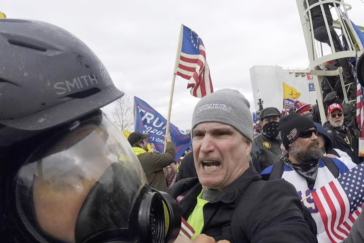 FILE - In this image from video, Alan William Byerly, center, attacks an Associated Press photographer during a riot at the U.S. Capitol in Washington, Jan. 6, 2021. On Sunday, Oct. 9, 2022, federal prosecutors recommended a prison sentence of nearly four years for Byerly, of Pennsylvania, who pleaded guilty to assaulting the AP photographer and using a stun gun against police officers during a mob's attack on the U.S. Capitol.