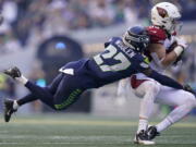 Arizona Cardinals tight end Zach Ertz, right, catches a pass in front of Seattle Seahawks cornerback Tariq Woolen (27) during the second half of an NFL football game in Seattle, Sunday, Oct. 16, 2022.