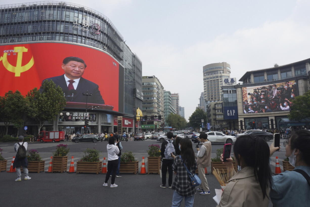 Chinese President Xi Jinping is seen at the end of the Chinese Communist Party's 20th Party Congress on a giant screen a commercial district of Hangzhou in eastern China's Zhejiang province on Sunday, Oct 23, 2022. China's economic growth accelerated in the latest quarter but still was among the slowest in decades as the country wrestled with repeated closures of cities to fight virus outbreaks.