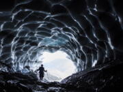 A man stands in a glacier cave at the Sardona glacier July 27 in Vaettis, Switzerland. The melting glacier has revealed a cave. Faced with increasing demand for alpine water resources at a time of accelerating glacier melt, policymakers from eight European countries are meeting in Switzerland to prevent a dispute over diminishing water resources from the highest peaks in the Alps.