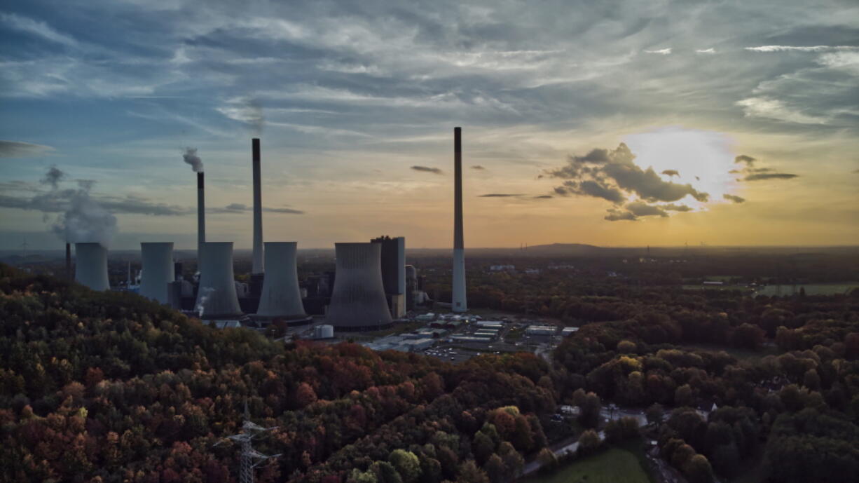 FILE - The sun sets behind a coal-fired power plant in Gelsenkirchen, Germany, Oct. 22, 2022. A new report from doctors and other health experts says the world's fossil fuel addiction is making the world sicker and is killing people.