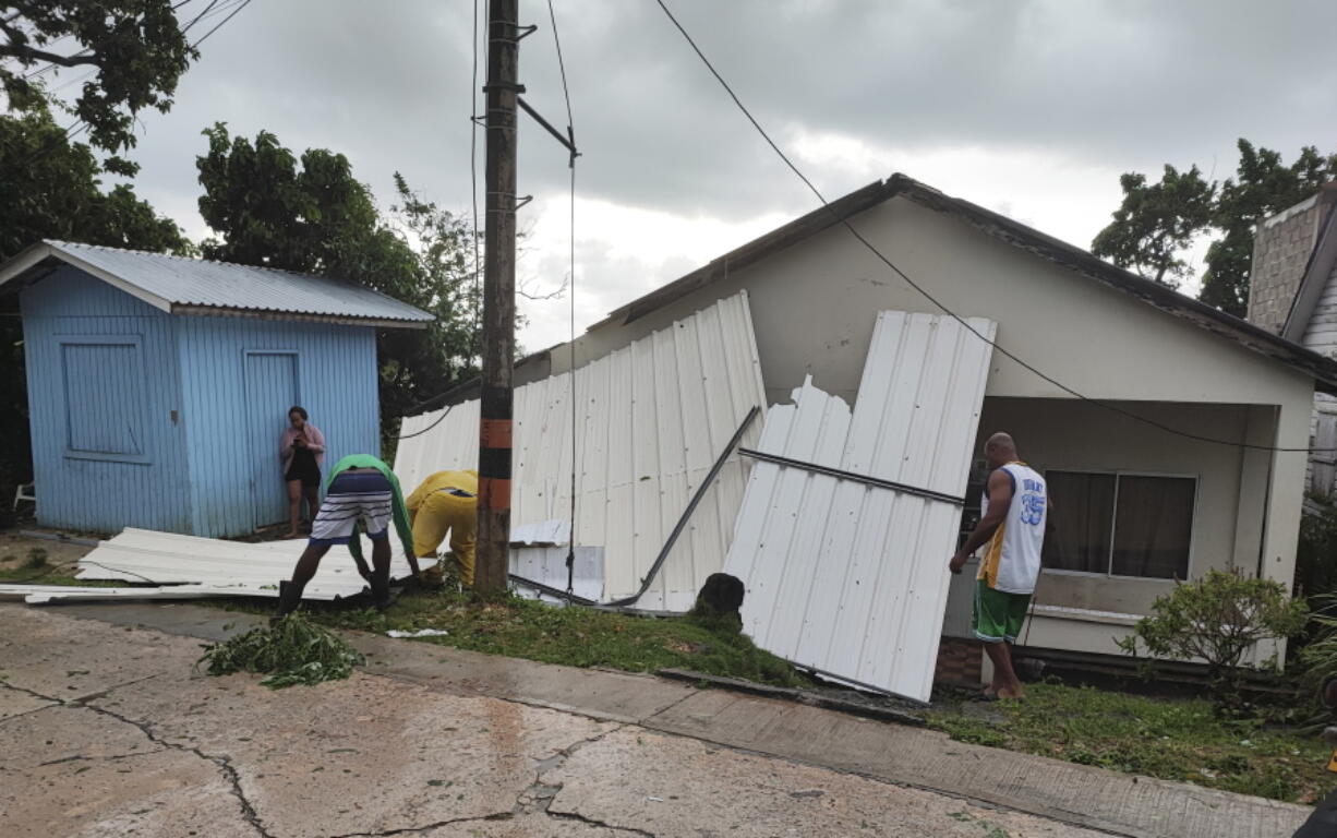 Men pick up a damaged roof in the aftermath of Hurricane Julia in San Andres island, Colombia, Sunday, Oct.9, 2022. Hurricane Julia hit Nicaragua's central Caribbean coast on Sunday after lashing Colombia's San Andres island, and a weakened storm was expected to emerge over the Pacific.