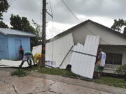 Men pick up a damaged roof in the aftermath of Hurricane Julia in San Andres island, Colombia, Sunday, Oct.9, 2022. Hurricane Julia hit Nicaragua's central Caribbean coast on Sunday after lashing Colombia's San Andres island, and a weakened storm was expected to emerge over the Pacific.