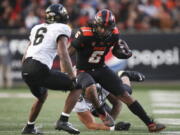 Oregon State running back Damien Martinez, front right, dodges Colorado cornerback Nikko Reed, front left, during the first half of an NCAA college football game on Saturday, Oct. 22, 2022, in Corvallis, Ore.