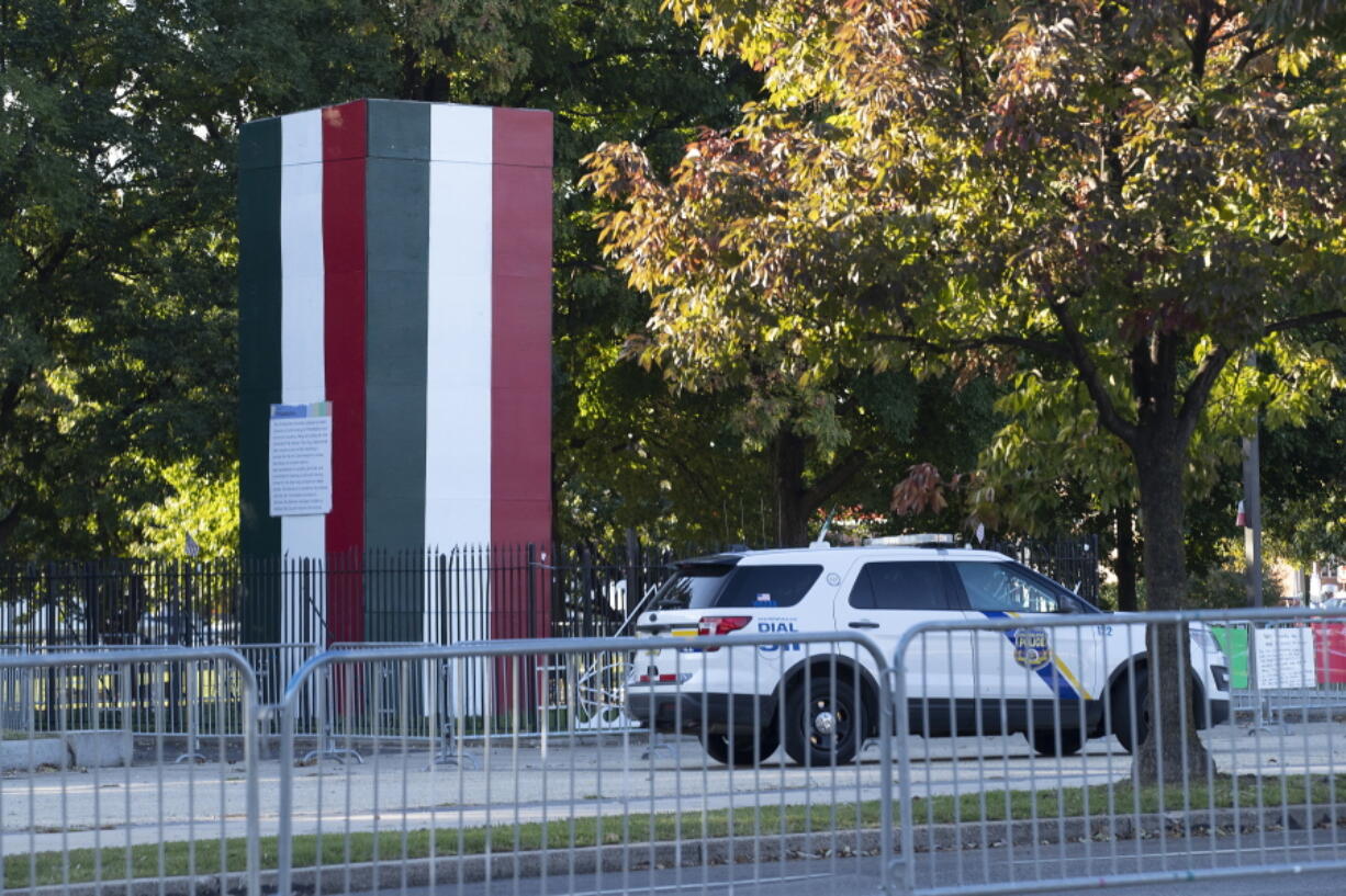 Police keep watch over the the Christopher Columbus statue in Philadelphia, Oct. 7, 2022. The statue remains hidden by a plywood box while its fate is decided in the courts, but the box has now been painted with the colors of the Italian flag. KYW reports that city officials told the station that they painted the box covering the 146-year-old statue in south Philadelphia's Marconi Plaza with the green, white and red stripes at the request of Councilman Mark Squilla, who represents the district. The new look came just in time for the holiday formerly named for the explorer and now celebrated in the city as Indigenous Peoples Day.