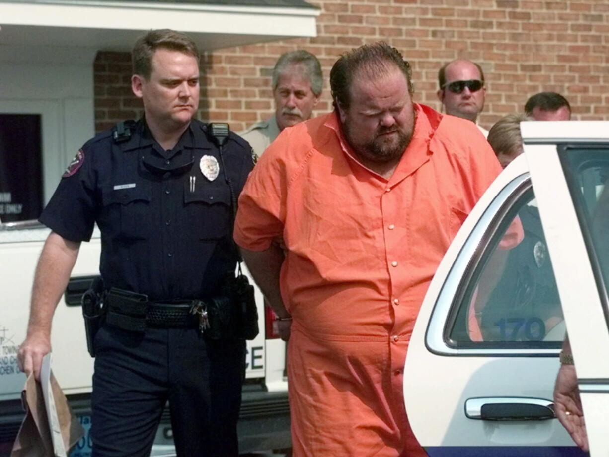 FILE - Officials escort murder suspect Alan Eugene Miller away from the Pelham City Jail in Alabama, Aug. 5, 1999. Miller said prison staff poked him with needles for over an hour as they tried to find a vein during an aborted lethal injection in September 2022. Miller's attorneys wrote about his experience during the execution attempt in a court filing made in October and they are trying to block the state from attempting a second lethal injection.