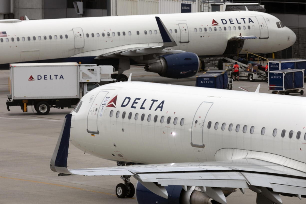 FILE - A Delta Air Lines plane leaves the gate on July 12, 2021, at Logan International Airport in Boston. On Friday, Oct. 21, 2022, Delta Air Lines settled allegations by a pilot who said the airline ordered her to undergo a psychiatric examination and barred her from flying in retaliation for raising safety concerns to company executives.