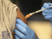 FILE - Medical personnel vaccinate students at a school in New Orleans on Jan. 25, 2022. A Centers for Disease Control and Prevention advisory committee on Thursday, Oct. 20, 2022 voted that the agency should update its recommended immunization schedules to add the COVID-19 vaccine, including to the schedule for children.