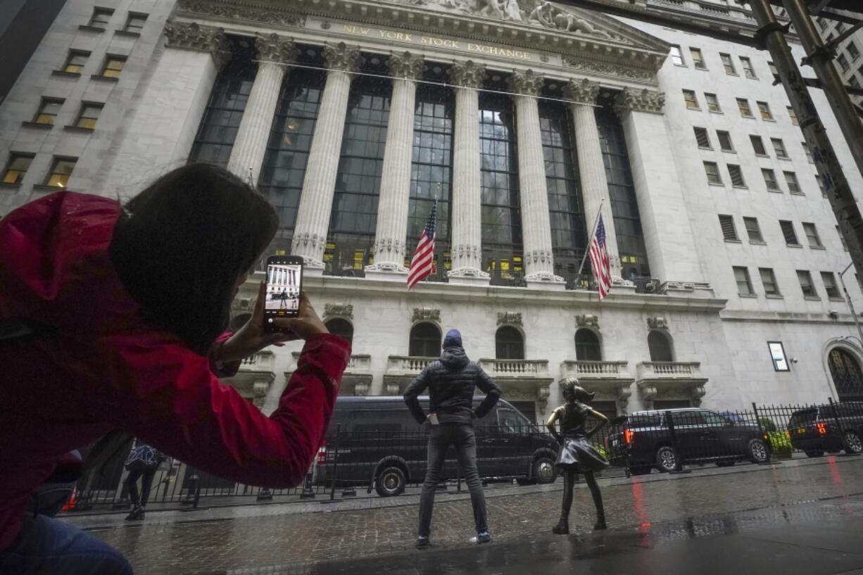 Visitors make photos with the 4-foot bronze Fearless Girl statue opposite the New York Stock Exchange, Monday, Oct. 3, 2022, in New York. Wall Street rallied to its best day since late July as the S&P 500 rose 2.6%.