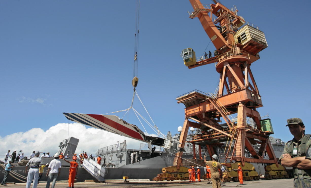 FILE - Workers unload debris, belonging to the crashed Air France flight AF447, from the Brazilian Navy's Constitution Frigate in the port of Recife, northeast of Brazil, June 14, 2009. It was the worst plane crash in Air France history, killing people of 33 nationalities and having lasting impact. It led to changes in air safety regulations, how pilots are trained and the use of airspeed sensors.