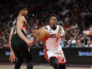 Miami Heat guard Kyle Lowry, right, passes the ball as Portland Trail Blazers guard Shaedon Sharpe, left defends during the first half of an NBA basketball game in Portland, Ore., Wednesday, Oct. 26, 2022.