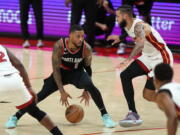 Portland Trail Blazers guard Damian Lillard, left, looks to drive past Miami Heat forward Caleb Martin, right, during the second half of an NBA basketball game in Portland, Ore., Wednesday, Oct. 26, 2022.