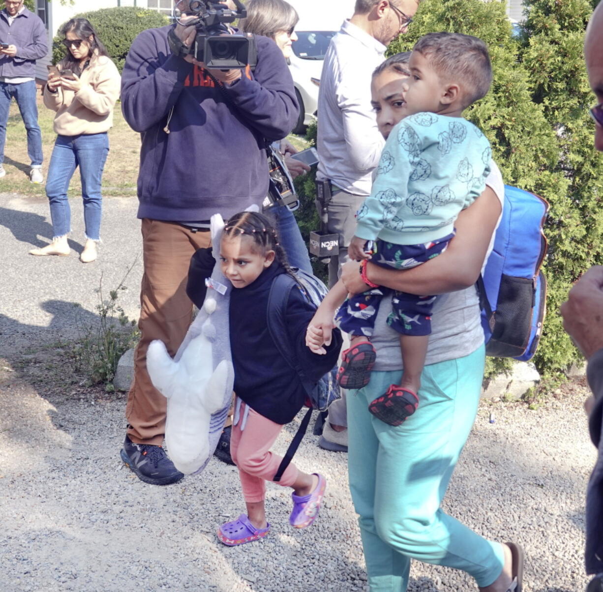 FILE - An immigrant family makes their way to the bus transporting from St. Andrews in Edgartown, Mass., to Vineyard Haven and the ferry to Woods Hole, Friday, Sept. 16, 2022. Florida officials began planning to transport migrants to other states in July and told potential contractors their task would be to relocate them on a voluntary basis, according to state documents released Friday, Oct. 7.