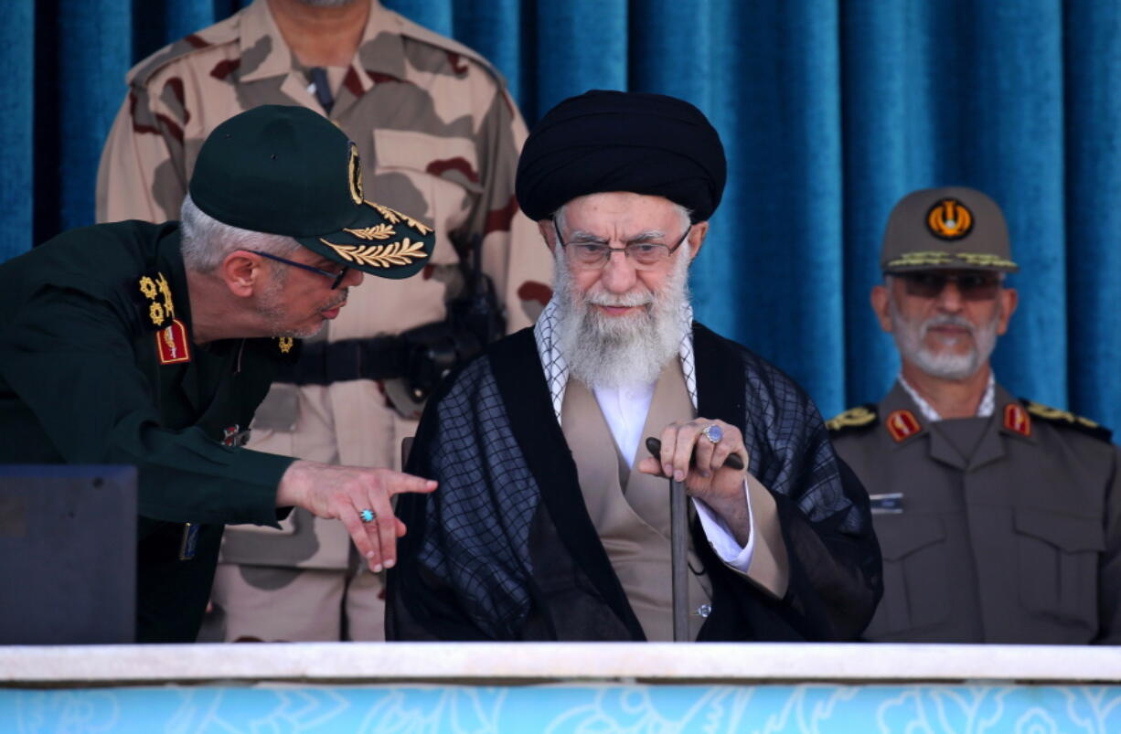 In this picture released by the official website of the office of the Iranian supreme leader, Supreme Leader Ayatollah Ali Khamenei, center, listens to chief of the General Staff of the Armed Forces Gen. Mohammad Hossein Bagheri at a graduation ceremony for a group of armed forces cadets at the police academy in Tehran, Iran, Monday, Oct. 3, 2022. Khamenei responded publicly on Monday to the biggest protests in Iran in years, breaking weeks of silence to condemn what he called "rioting" and accuse the U.S. and Israel of planning the protests.