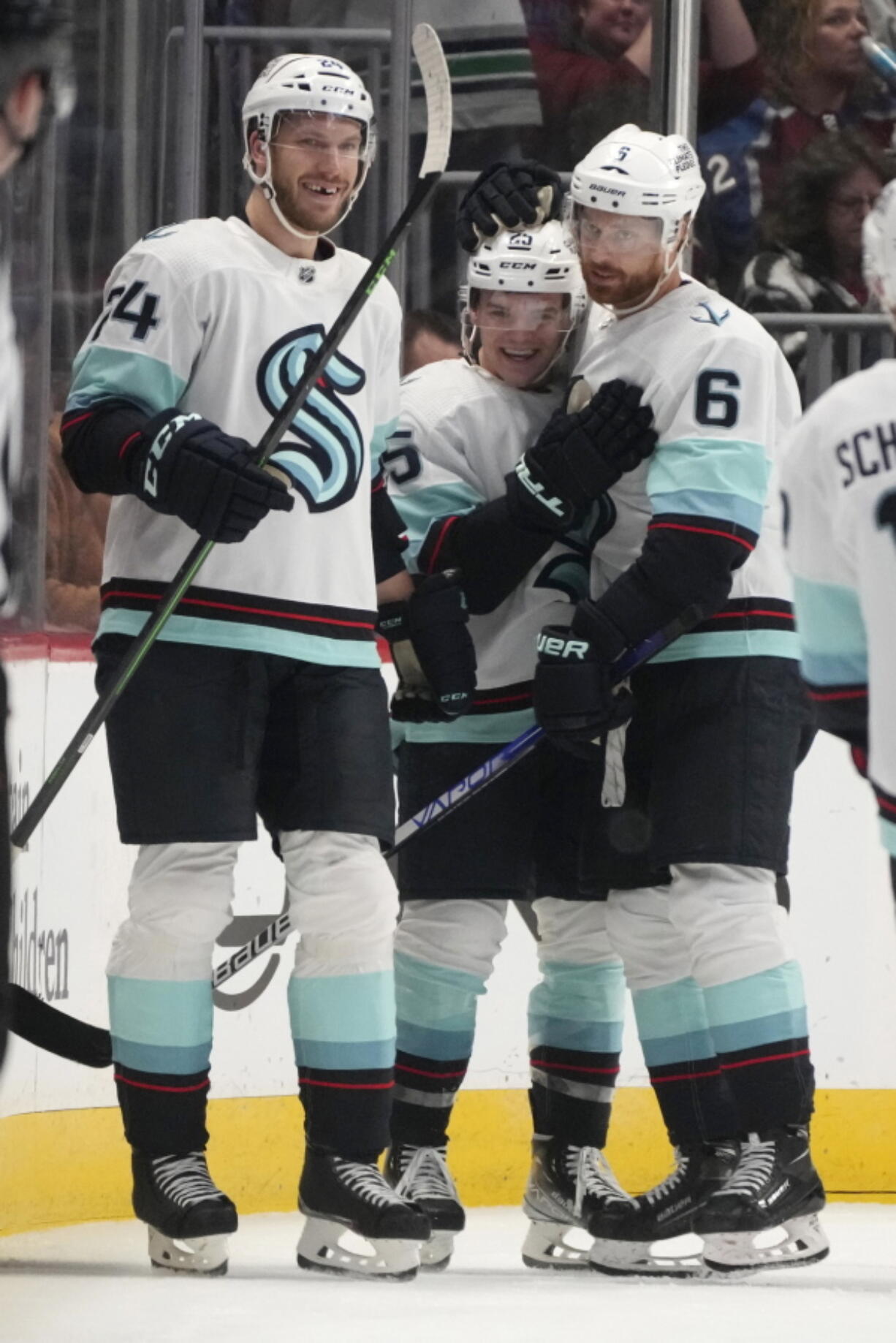 Seattle Kraken center Karson Kuhlman, center, is congratulated, after scoring the go-ahead goal against the Colorado Avalanche, by defensemen Jamie Oleksiak, left, and Adam Larsson during the third period of an NHL hockey game Friday, Oct. 21, 2022, in Denver.