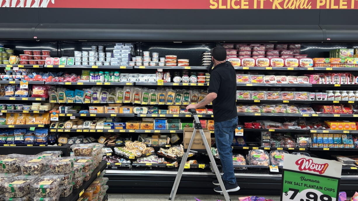 An employee stocks refrigerated items at a Grocery Outlet store in Pleasanton, Calif., on Sept. 15.