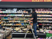 An employee stocks refrigerated items at a Grocery Outlet store in Pleasanton, Calif., on Sept. 15.