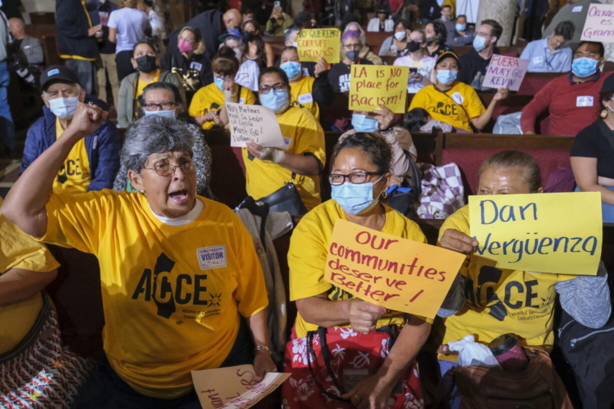 FILE - People hold signs and shout slogans before the starting the Los Angeles City Council meeting on Tuesday, Oct. 11, 2022 in Los Angeles. Cross-cultural coalitions have ruled Los Angeles politics for decades, helping elect both Black and Latino politicians to top leadership roles in the racially and ethnically diverse second largest city in America. But the year old recording of racist comments by the city's City Council president has laid bare the tensions over political power that have long quietly simmered between the Latino and Black communities. (AP Photo/Ringo H.W.