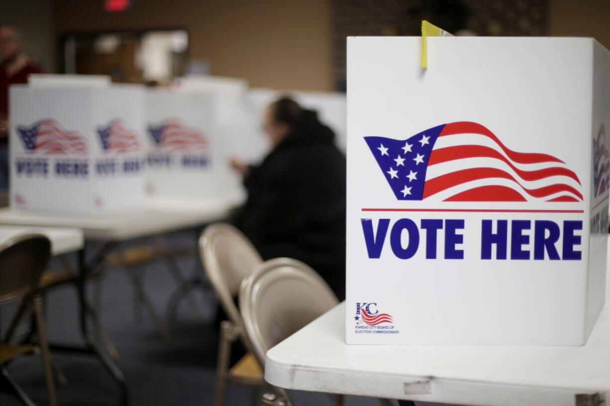 FILE - A woman votes in the presidential primary election at the the Summit View Church of the Nazarene in Kansas City, Mo., on March 10, 2020. Newspaper endorsements for candidates are fading away, a victim of both the news industry's troubles and the era's bitter politics. Earlier this month, newspapers controlled by hedge fund Alden Global Capital said they would no longer endorse candidates for president, governor and U.S. Senate. They include dozens of dailies like the Chicago Tribune, New York Daily News, Boston Herald, Orlando Sentinel and San Jose Mercury News.