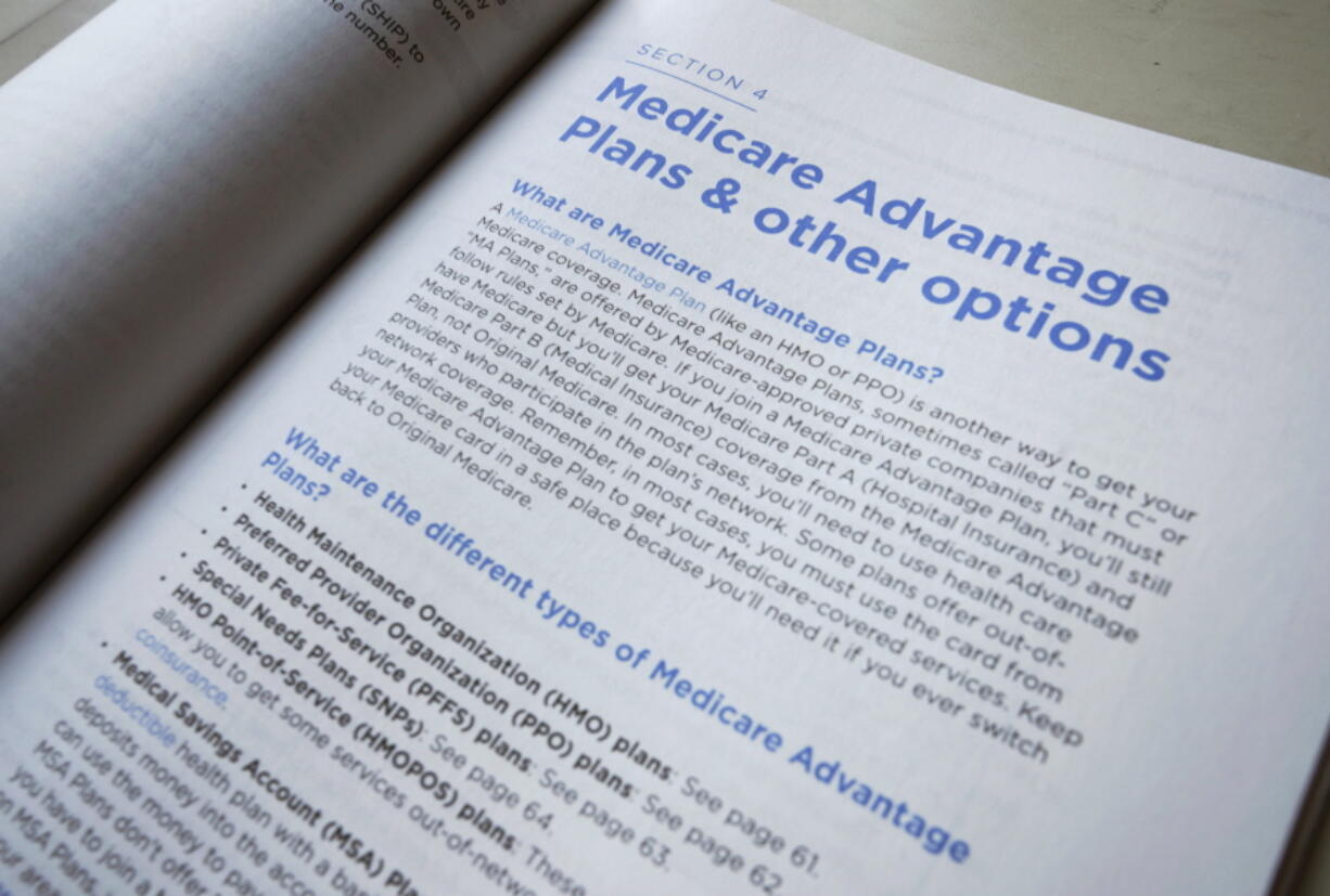 FILE - This Nov. 8, 2018 file photo shows a page from the 2019 U.S. Medicare Handbook in Washington.  Health insurers will flood the Medicare Advantage market again this fall with enticing offers of plans that have no monthly price tag. The number of so-called zero-premium plans has been growing for years, and they can appeal to retirees who live on fixed incomes.