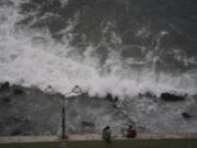 People relax at the beach front in Mazatlan, Mexico, Sunday, Oct. 2, 2022. Hurricane Orlene, at Category 3 strength, is heading for a collision with Mexico's northwest Pacific coast between the tourist towns of Mazatlan and San Blas.