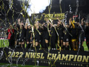 Portland Thorns FC celebrate with the trophy after they won the NWSL championship soccer match against the Kansas City Current, Saturday, Oct. 29, 2022, in Washington. Portland won 2-0.