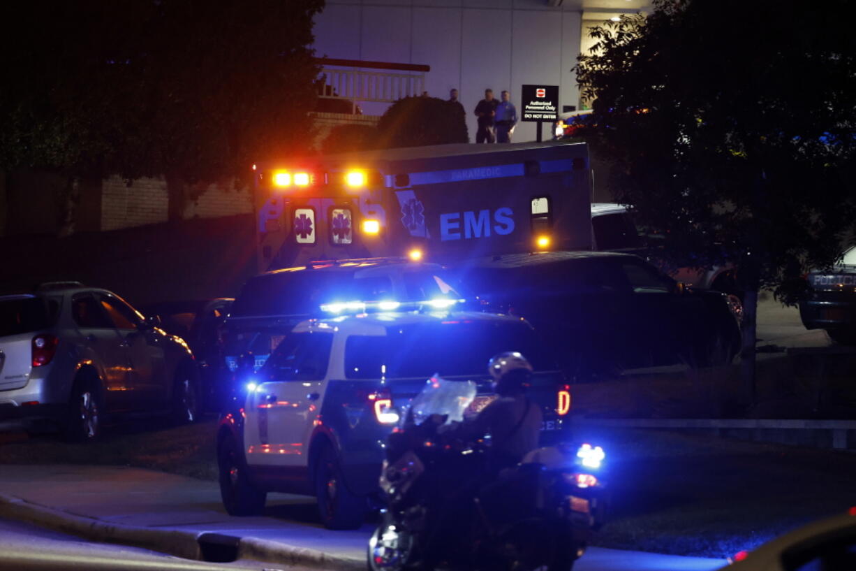 An ambulance believed to be carrying a shooting suspect arrives at Wake Medical Center Emergeny Room in Raleigh, N.C., Thursday, Oct. 13, 2022 surrounded by police.