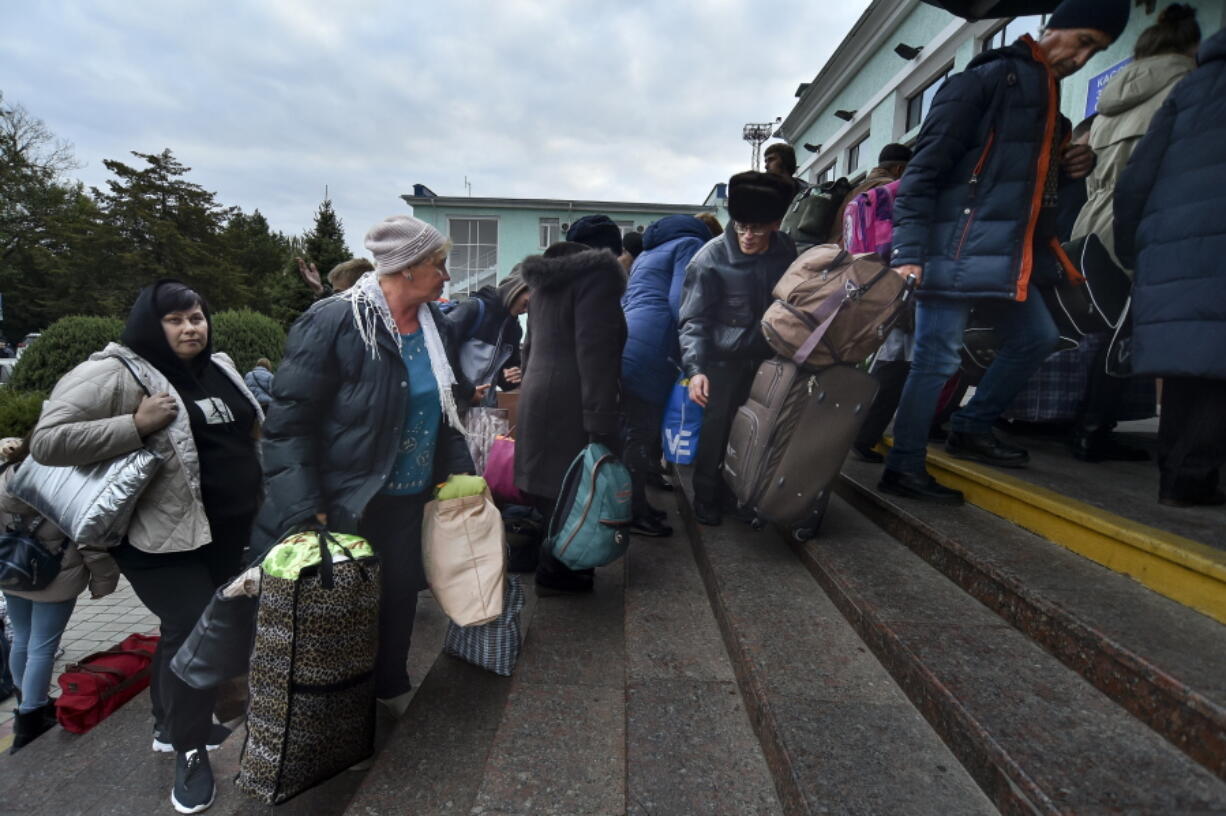 Evacuees from Kherson gather upon their arrival at the railway station in Dzhankoi, Crimea, Friday, Oct. 21, 2022. Russian authorities have encouraged residents of Kherson to evacuate, warning that the city may come under massive Ukrainian shelling.