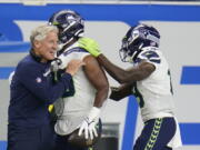 Seattle Seahawks head coach Pete Carroll hugs running back Rashaad Penny after Penny's touchdown during the second half of an NFL football game against the Detroit Lions, Sunday, Oct. 2, 2022, in Detroit.