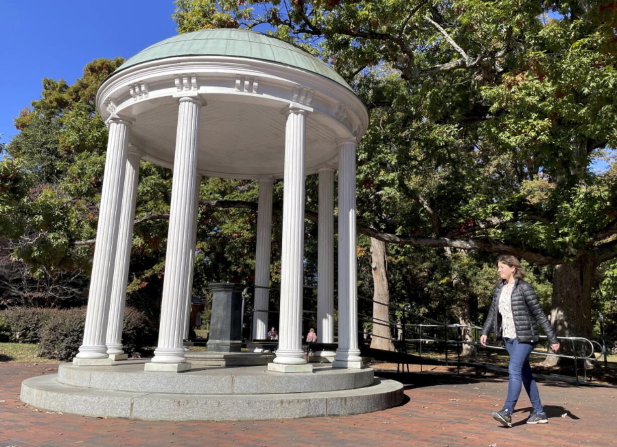 A student walks by the Old Well at the University of North Carolina Chapel Hill, a rotunda and campus landmark at the southern end of McCorkle Place, on Monday. A Confederate statue known as Silent Sam stood in the plaza before it was toppled by protesters in 2018.