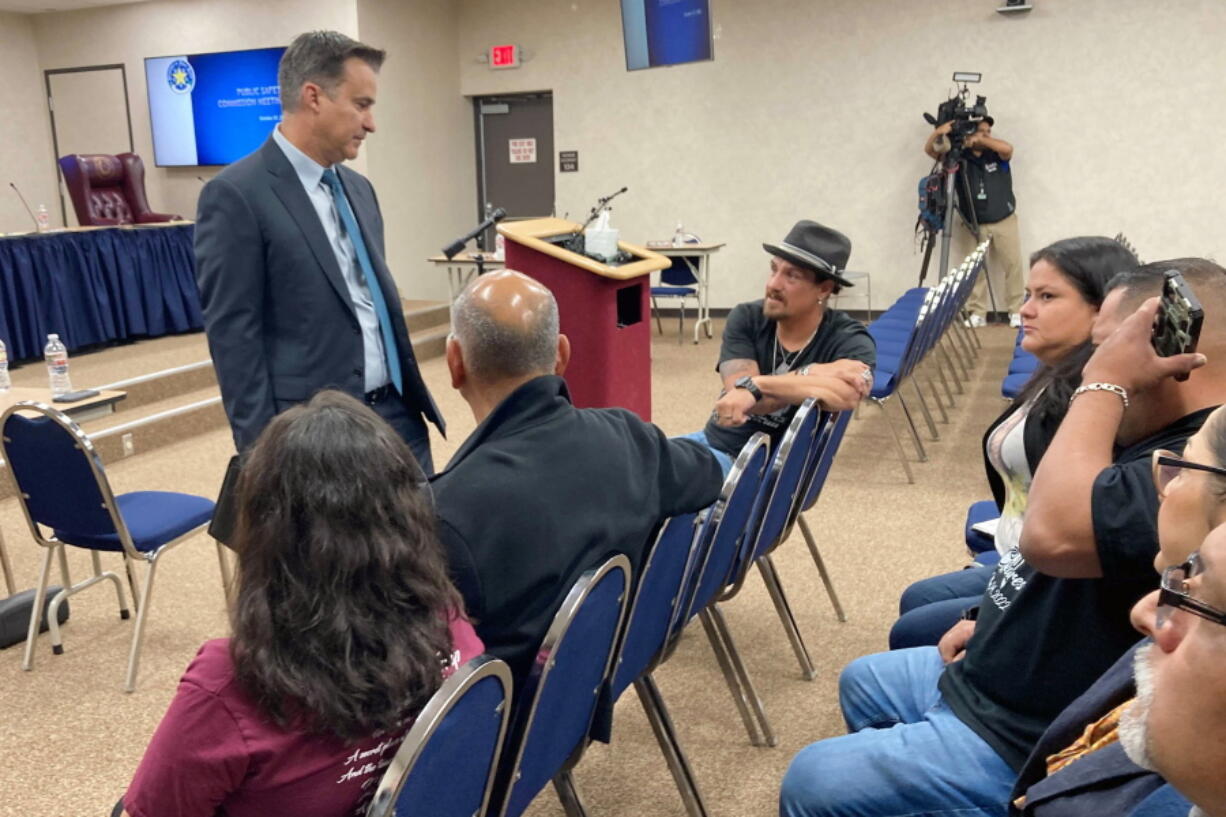 Texas state Sen. Roland Gutierrez, left, speaks to family members of children slain in the Uvalde school shooting ahead of a meeting of the state Law Enforcement Commission in Austin, Texas, on Thursday, Oct. 27, 2022. Col. Steve McCraw, the head of the Texas Department of Public Safety, said during the meeting Thursday that a criminal investigation surrounding the massacre is looking at law enforcement officers over the hesitant police response to the shooting and will be completed by the end of the year.