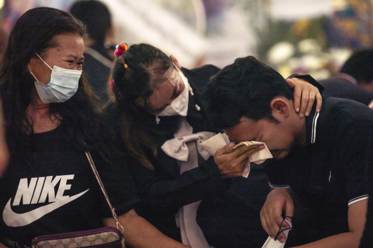 Relatives console Seksan Sriraj, 28, who lost his pregnant wife in a mass killing attack, at Wat Rat Samakee temple in Uthai Sawan, north eastern Thailand, Saturday., Oct. 8, 2022. A former police officer burst into a day care center in northeastern Thailand on Thursday, killing dozens of preschoolers and teachers before shooting more people as he fled.